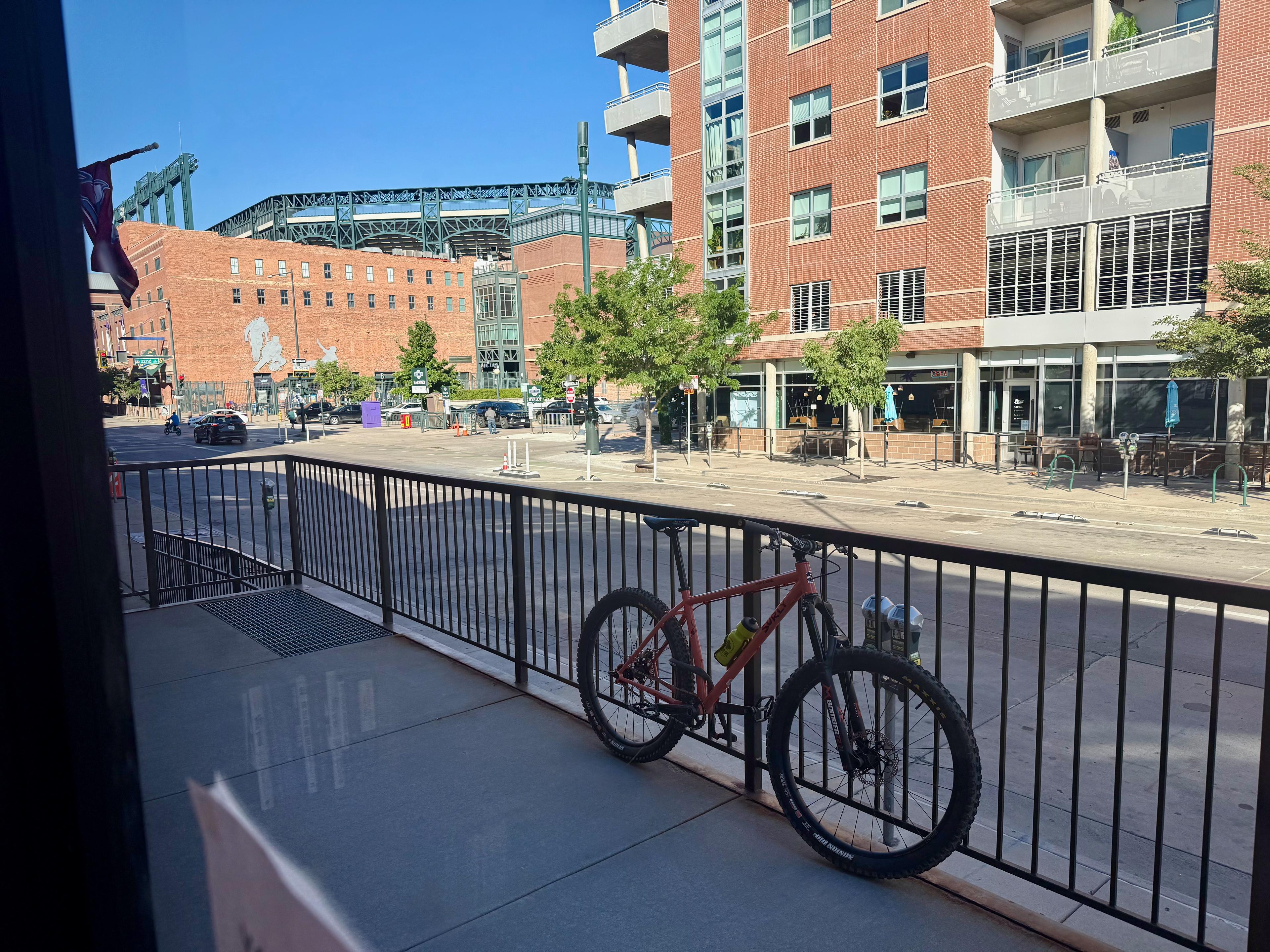 Karate Monkey locked to a railing on a city street near a stadium