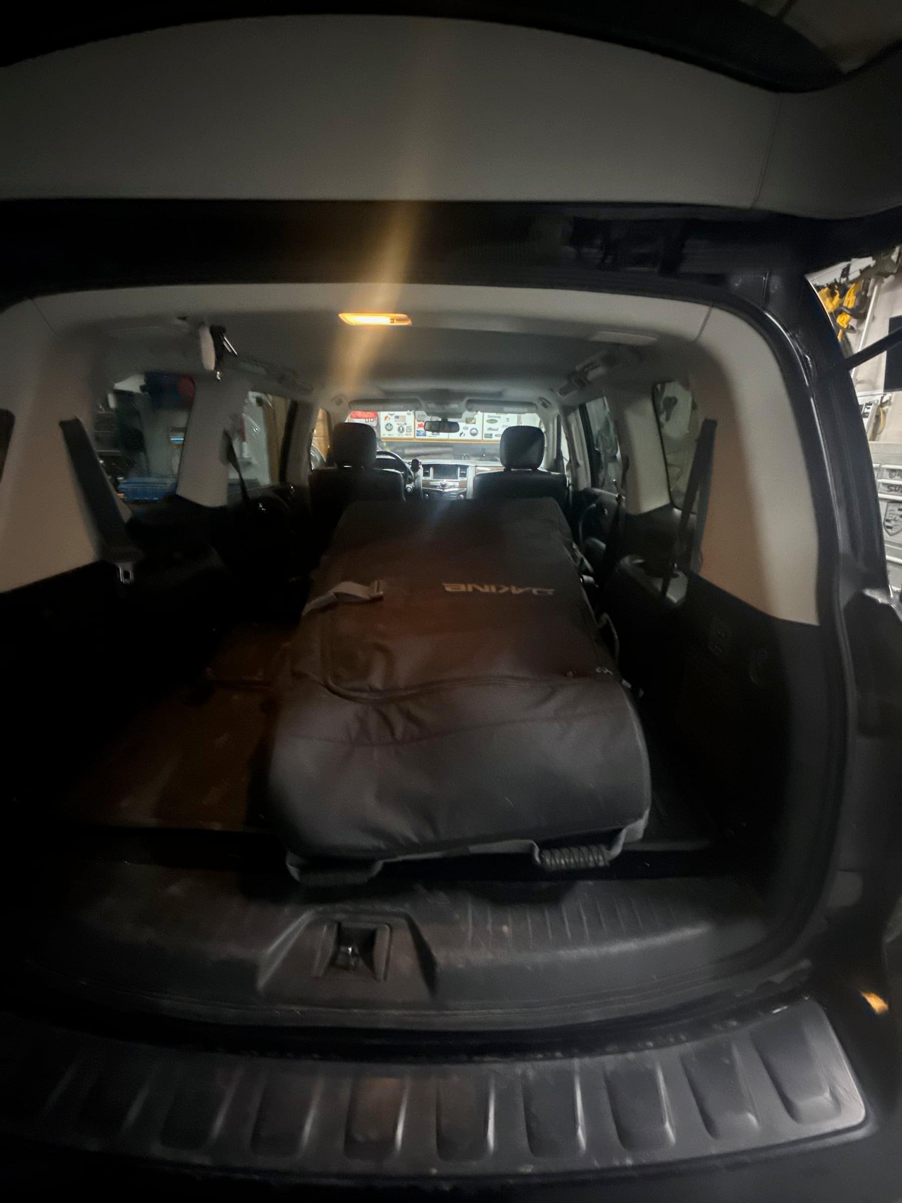 A black Dakine bike bag lying in the back of a Nissan Armada with the seats folded down, photographed before the drive to the airport