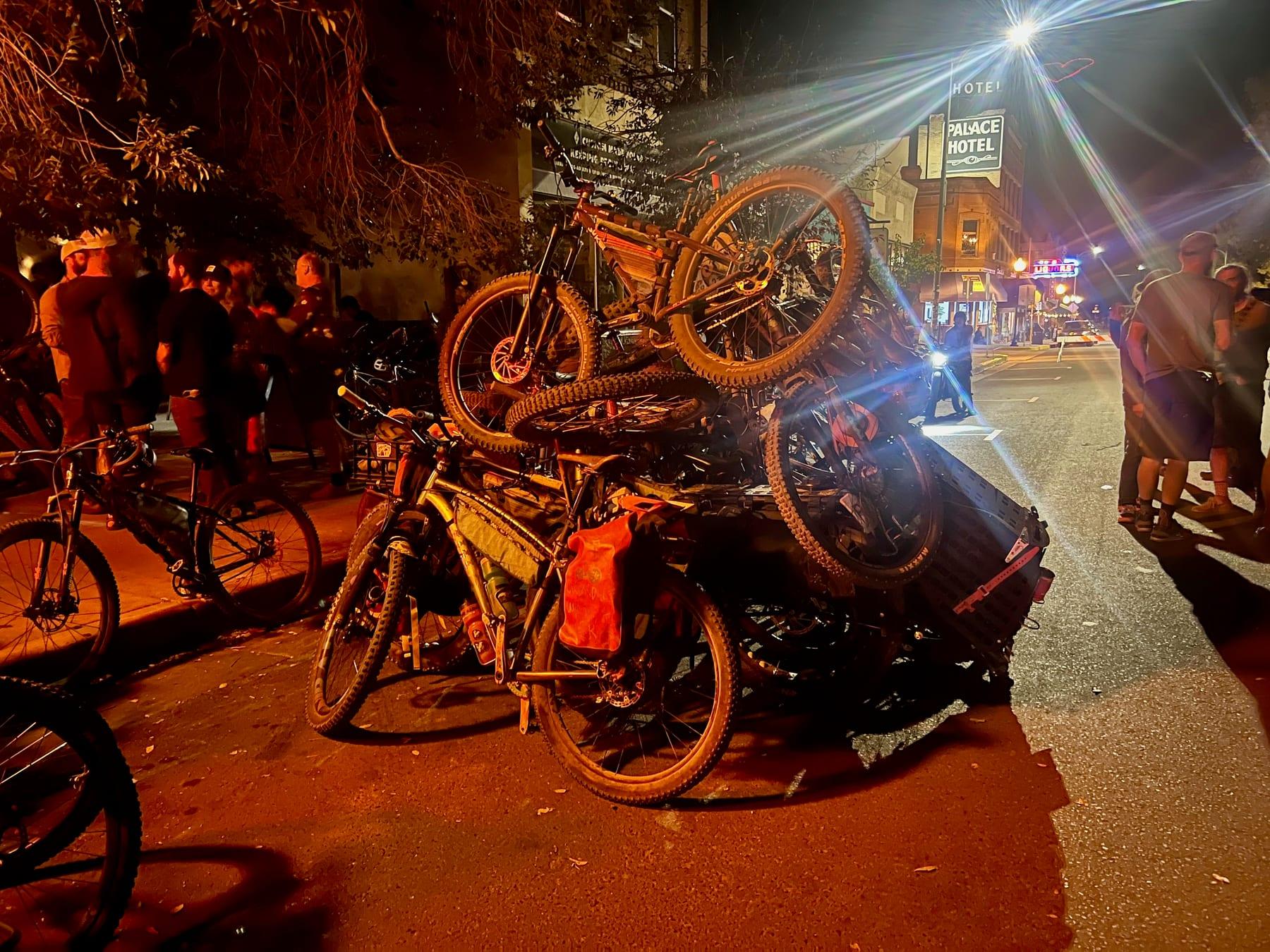 Large pile of bikes outside the Palace Hotel at night