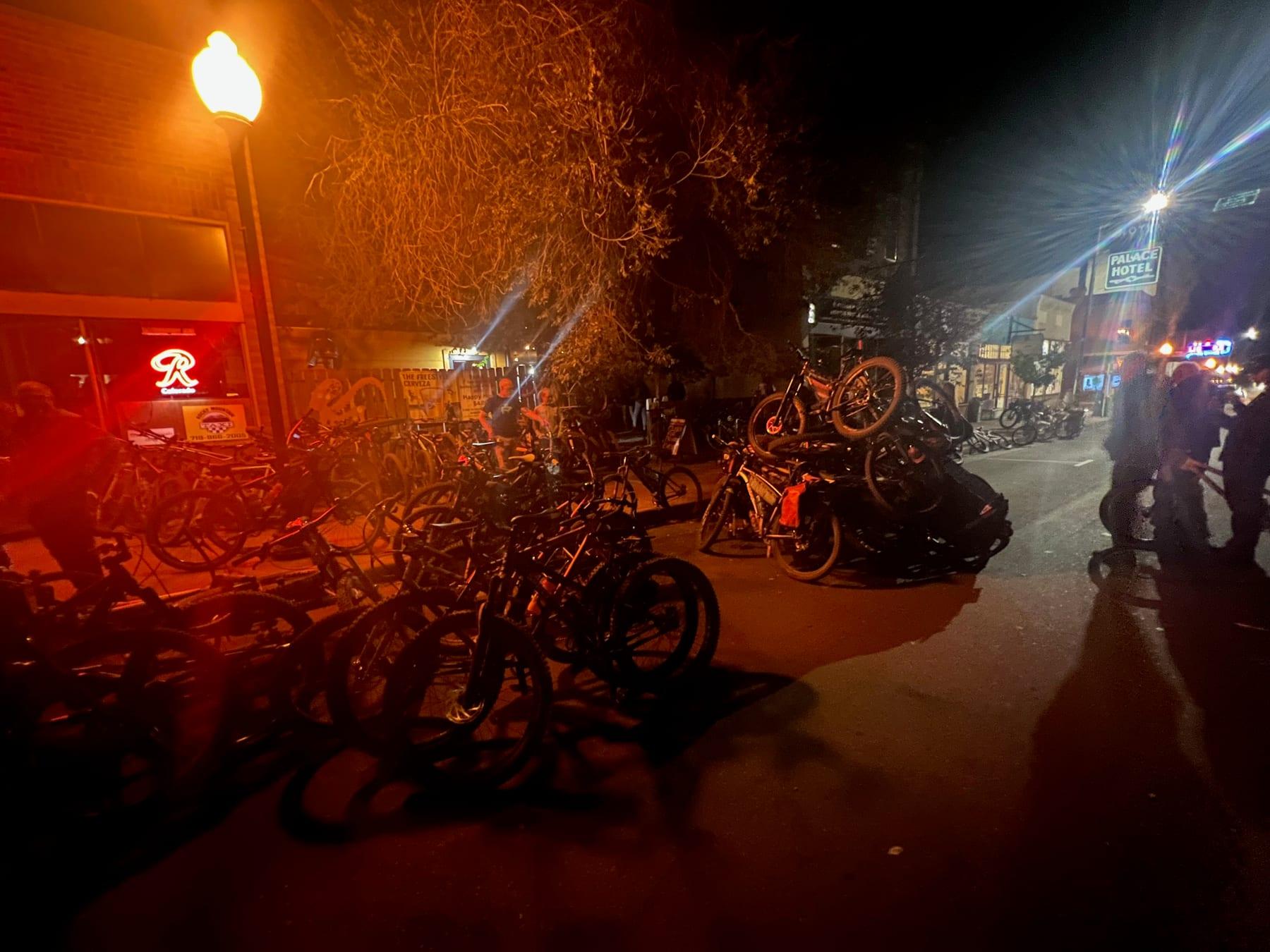 Bikes piled at night near an open flame downtown