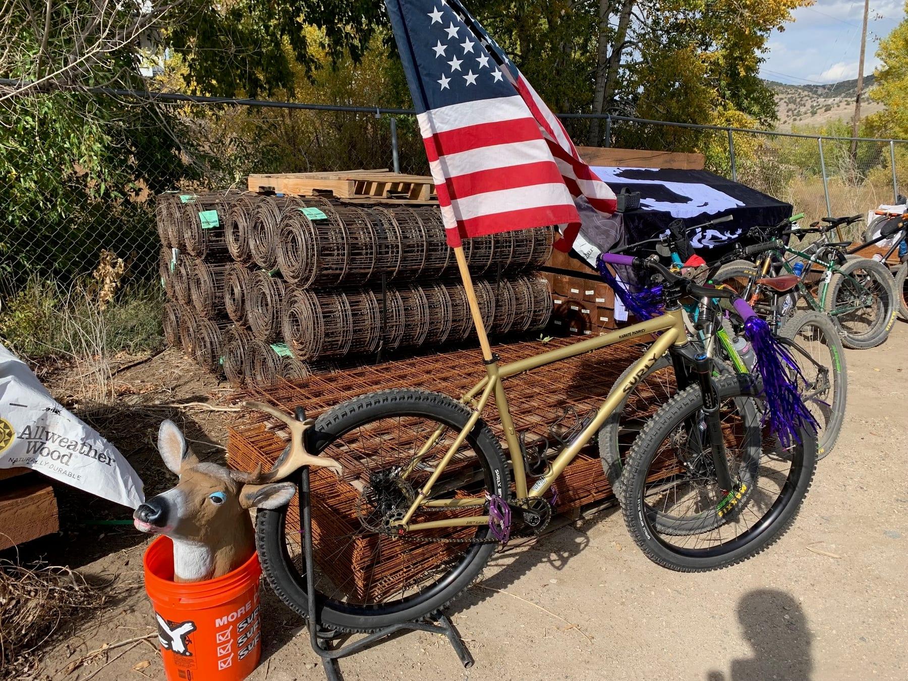 Bike loaded with wood, an American flag, and a deer skull at the town lumberyard