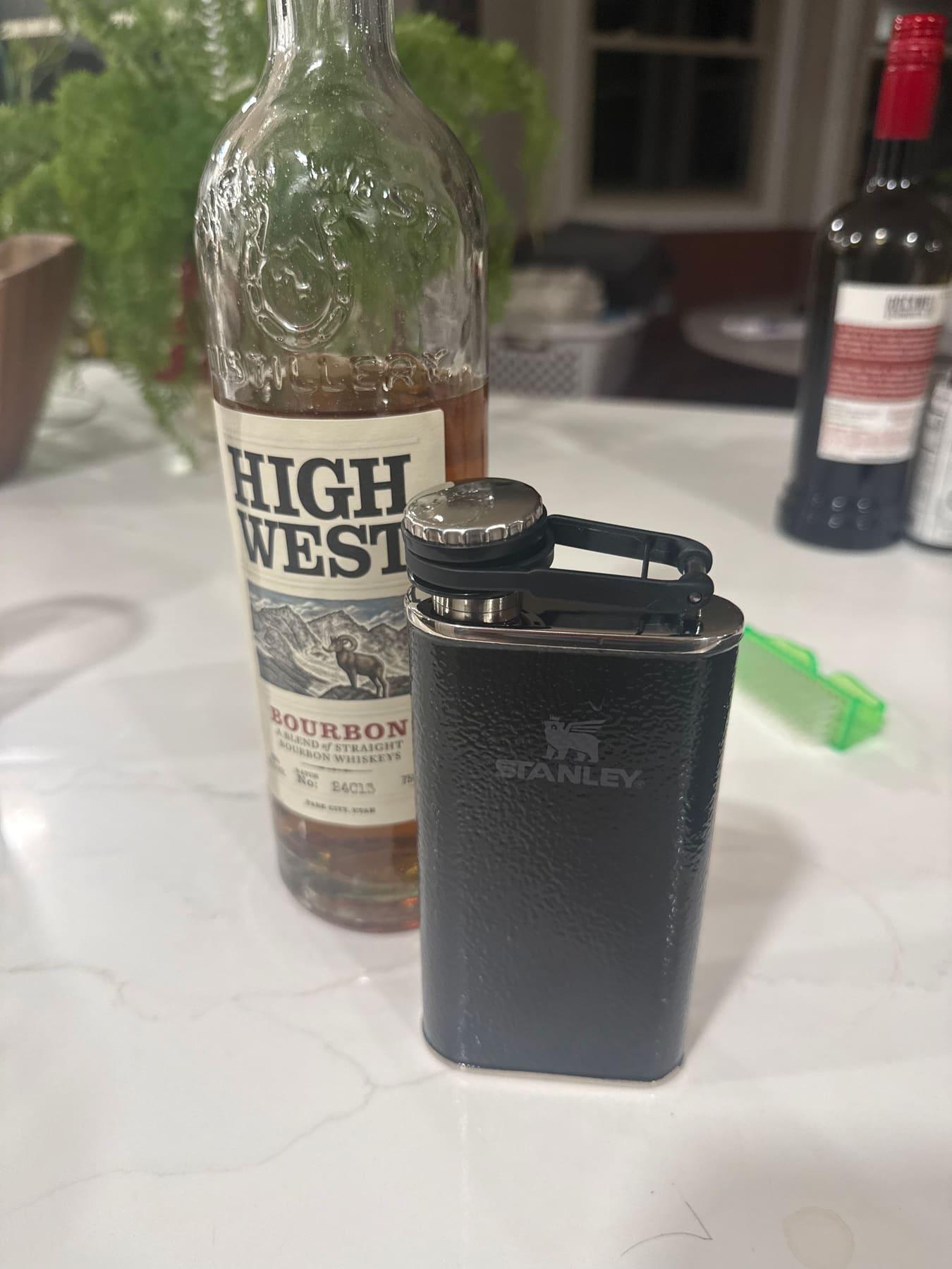 Bottle of High West bourbon and a flask sitting on the bar table during registration