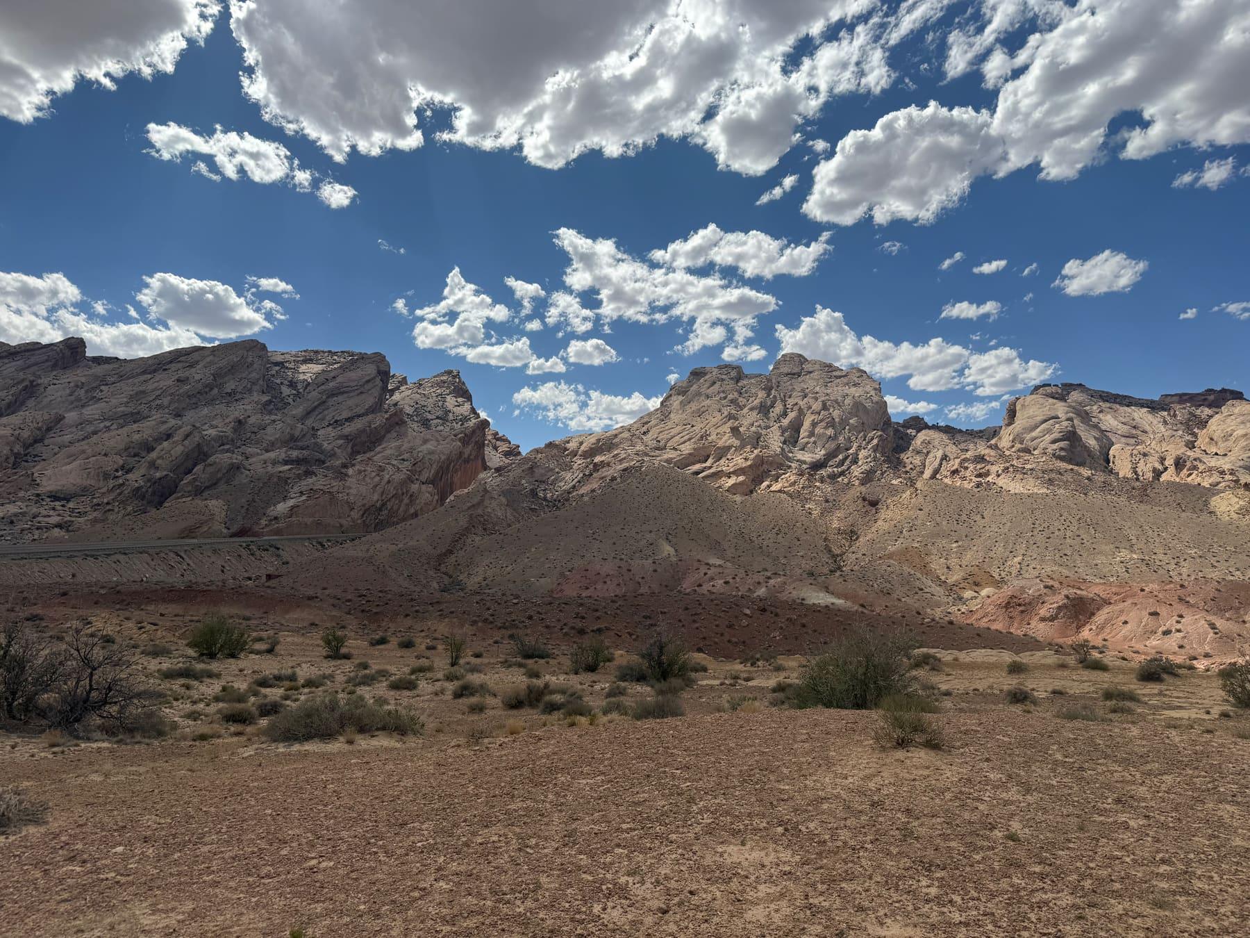 Highway rest stop with mountains and desert scrub visible under a partly cloudy sky along Interstate 70 in Utah