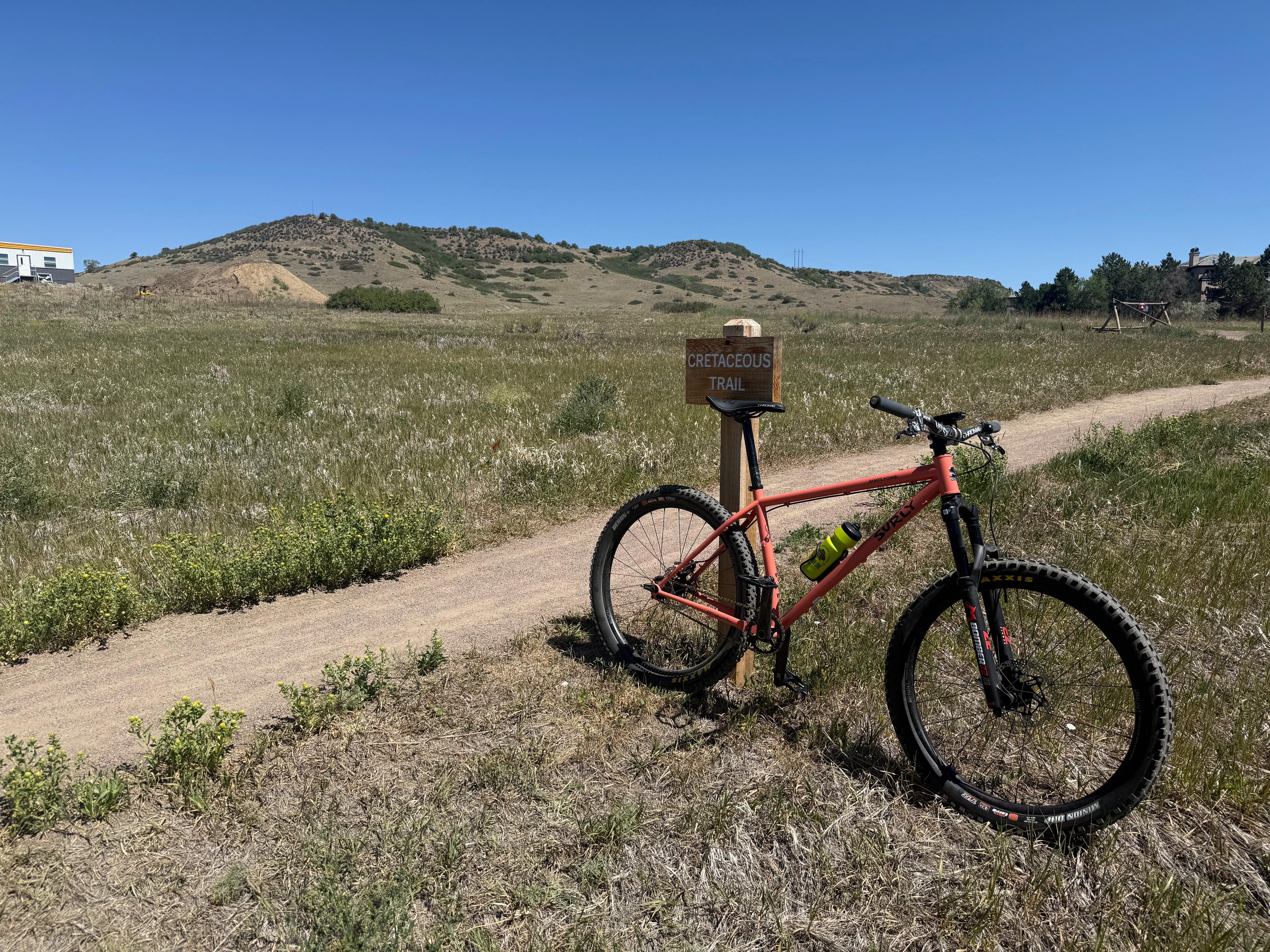 Single-speed mountain bike leaning against the Cretaceous Trail sign at the base of South Table Mountain in Golden, Colorado