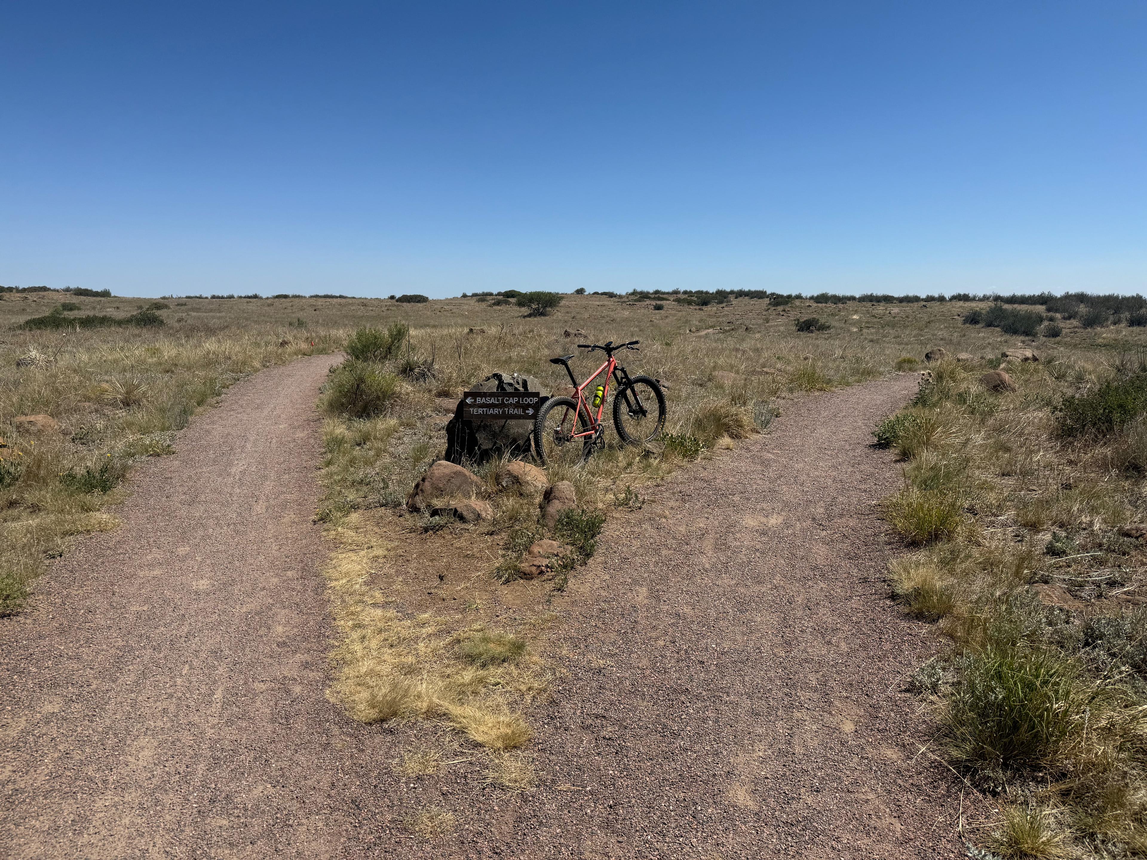 Wider view of the same Basalt Cap Loop and Tertiary Trail junction, showing both trails splitting across the mesa
