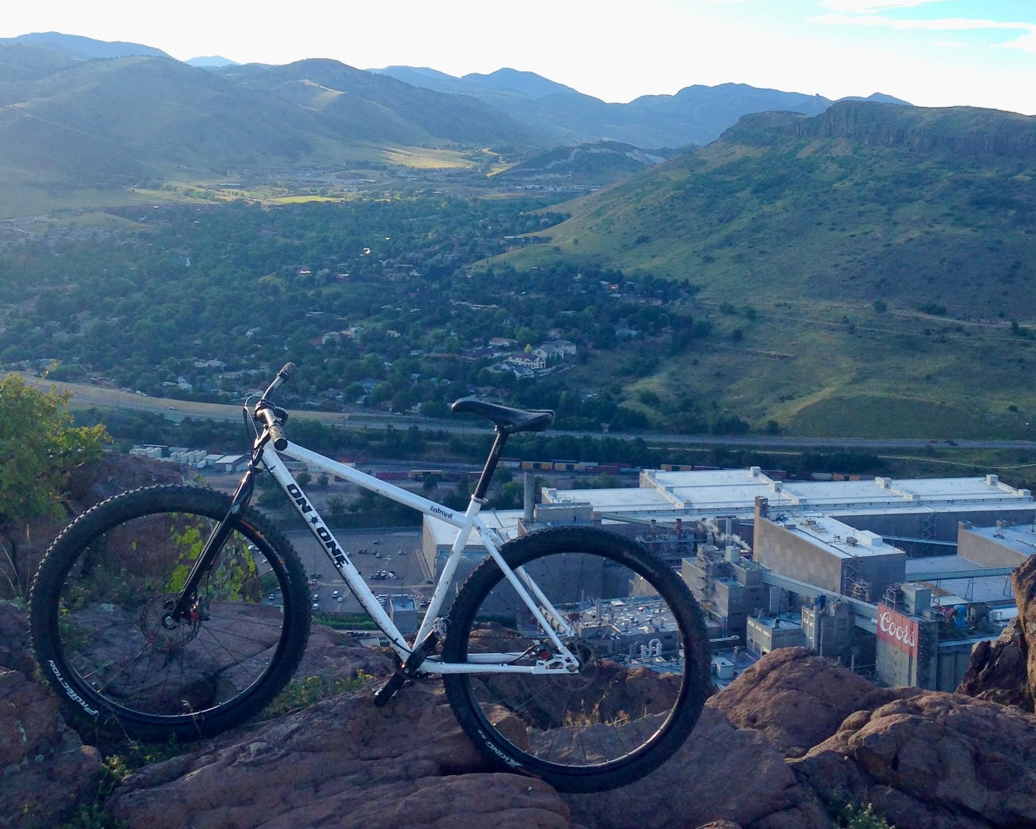 Mountain bike on a rocky overlook above Golden, Colorado, with the Coors brewery and the valley below